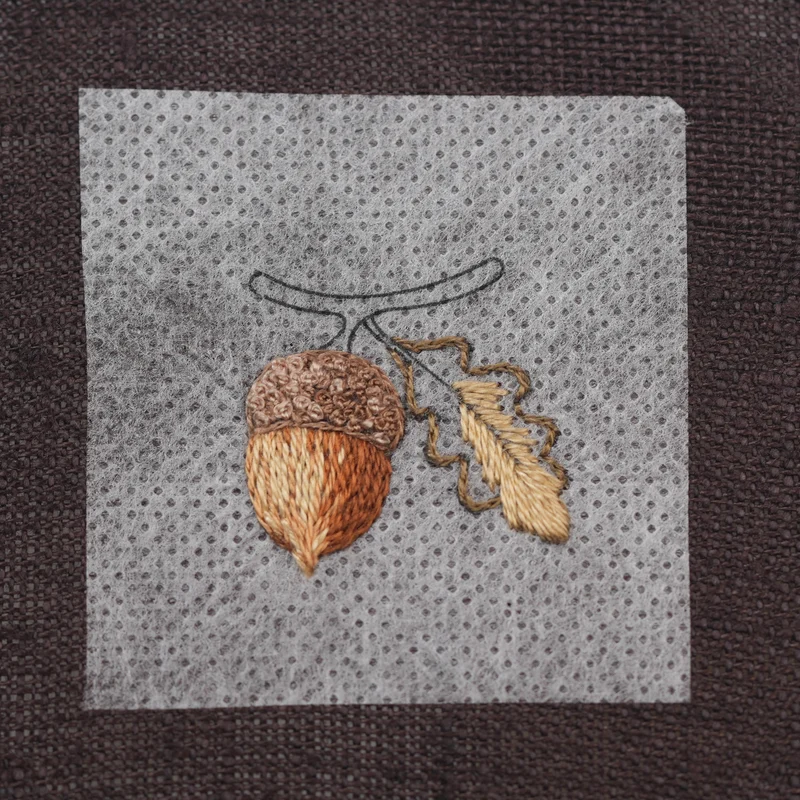 Embroider the tip of the leaf with DMC 422, extending the stitches slightly over the DMC 610 split-stitch outline. Then use DMC 422 to fill the inner section of the leaf.