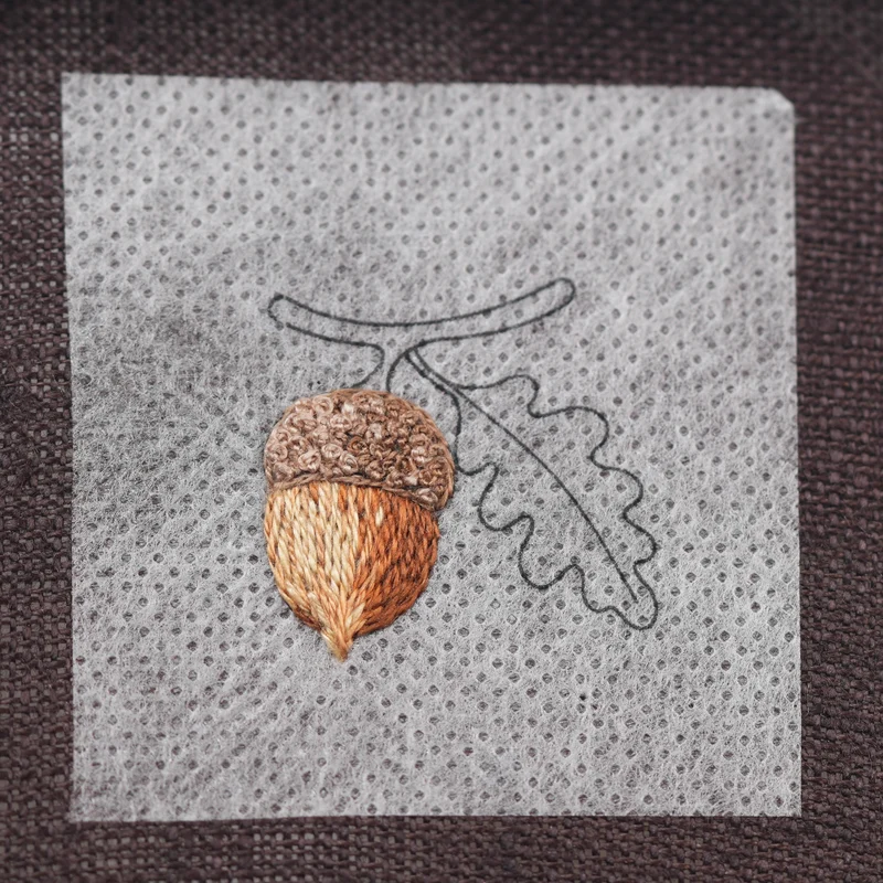 Fill the remaining gaps with French knots using DMC 3864, blending them evenly with the previous shades.