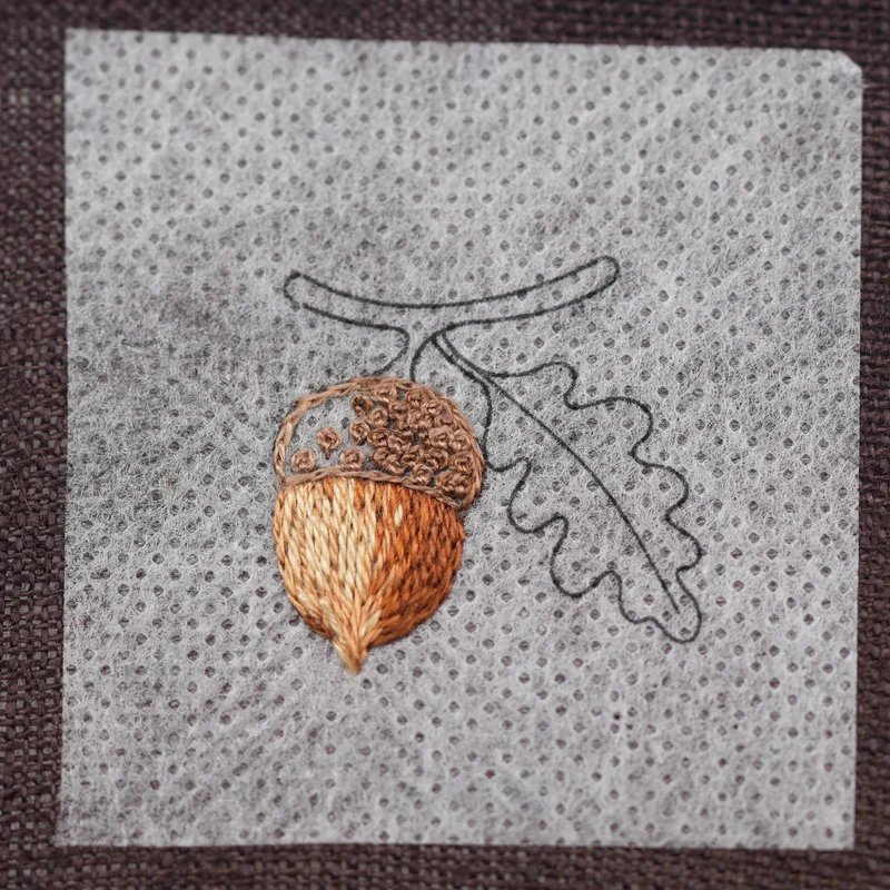 Outline the left side of the acorn cap with split stitch. Add French knots across the center, extending some into both the left and right sides to blend naturally with DMC 3862.