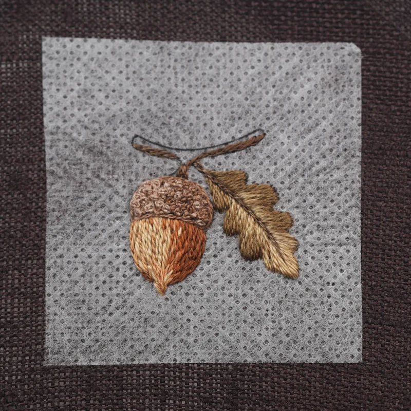Embroider the lower part of the branch with DMC 3781 using split stitch, then add the center vein of the leaf using the same stitch and shade.